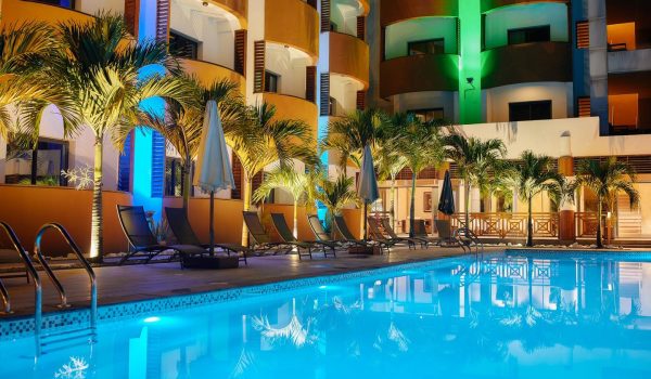 Piscine de l’Hôtel Marina Beach à Tamatave, Madagascar, entourée de palmiers pendant un événement à la tombée de la nuit